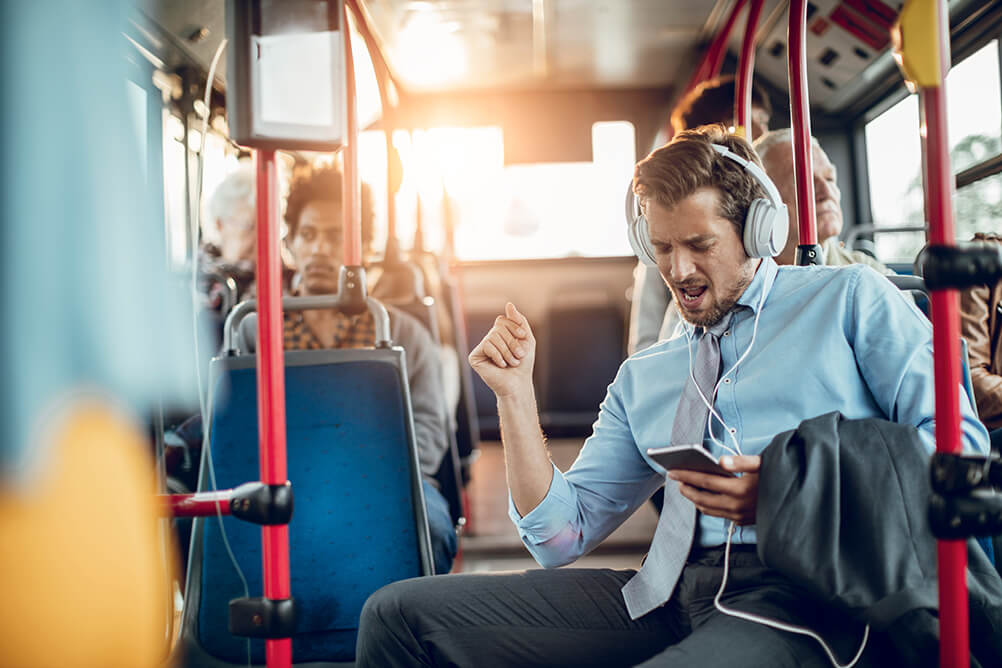 man travelling by bus listening to music