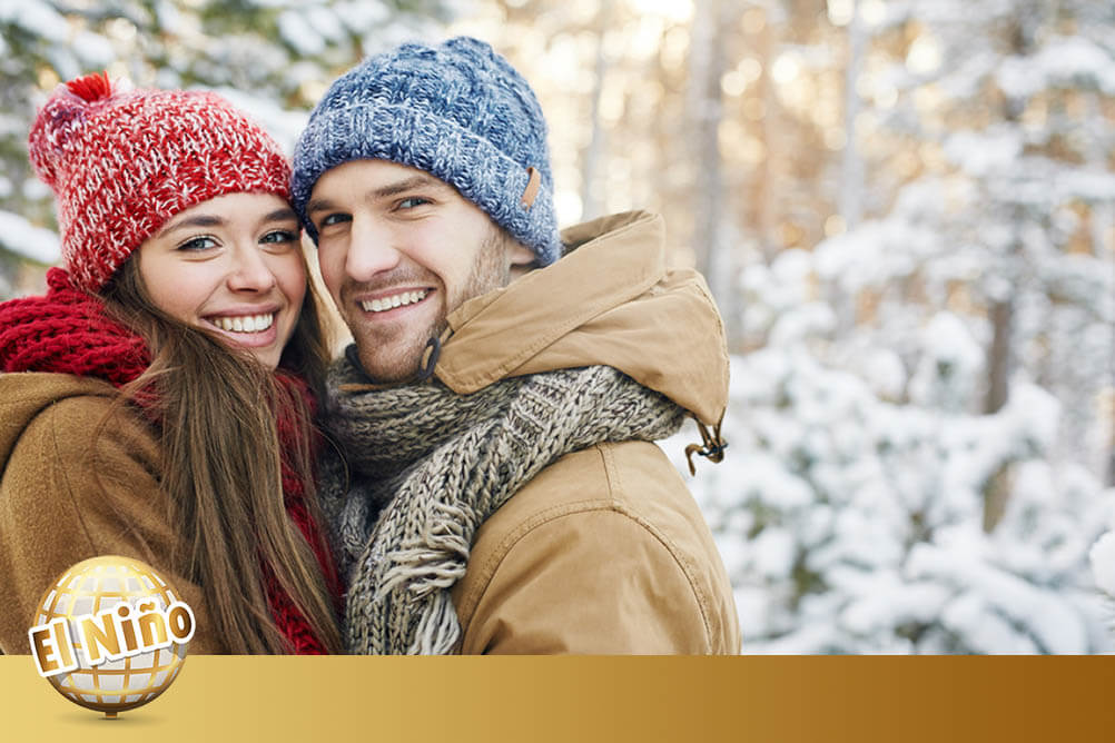 El Niño Spanish New Year Lottery Smiling couple dressed in winter clothes stand outside in the snow