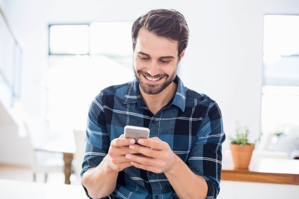 Man looking at smartphone and smiling
