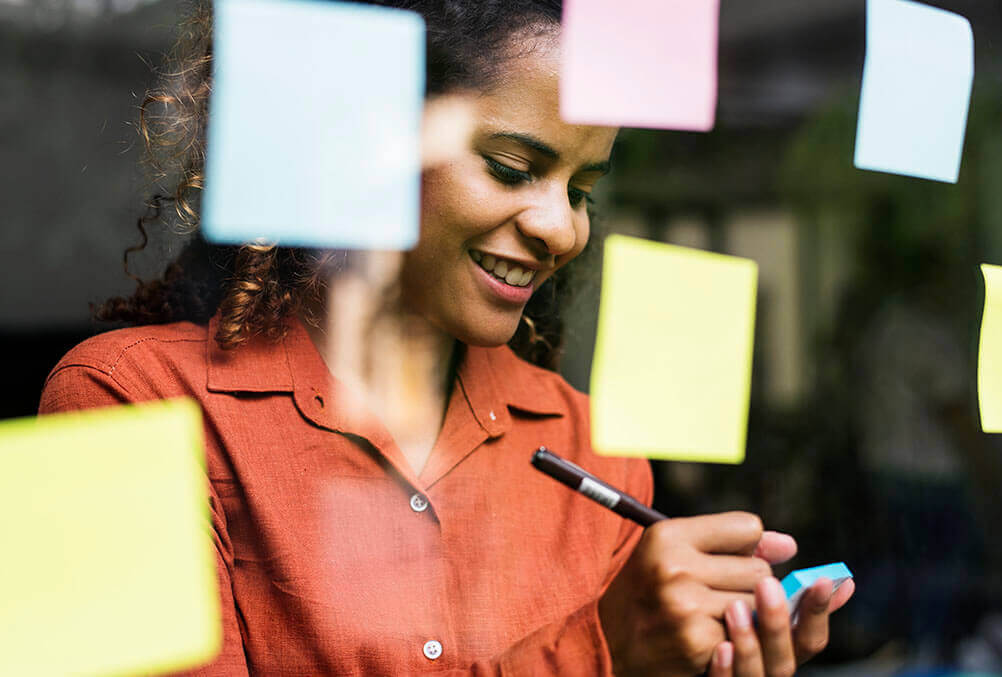 Woman makes notes of the next lottery draw on a post-it note