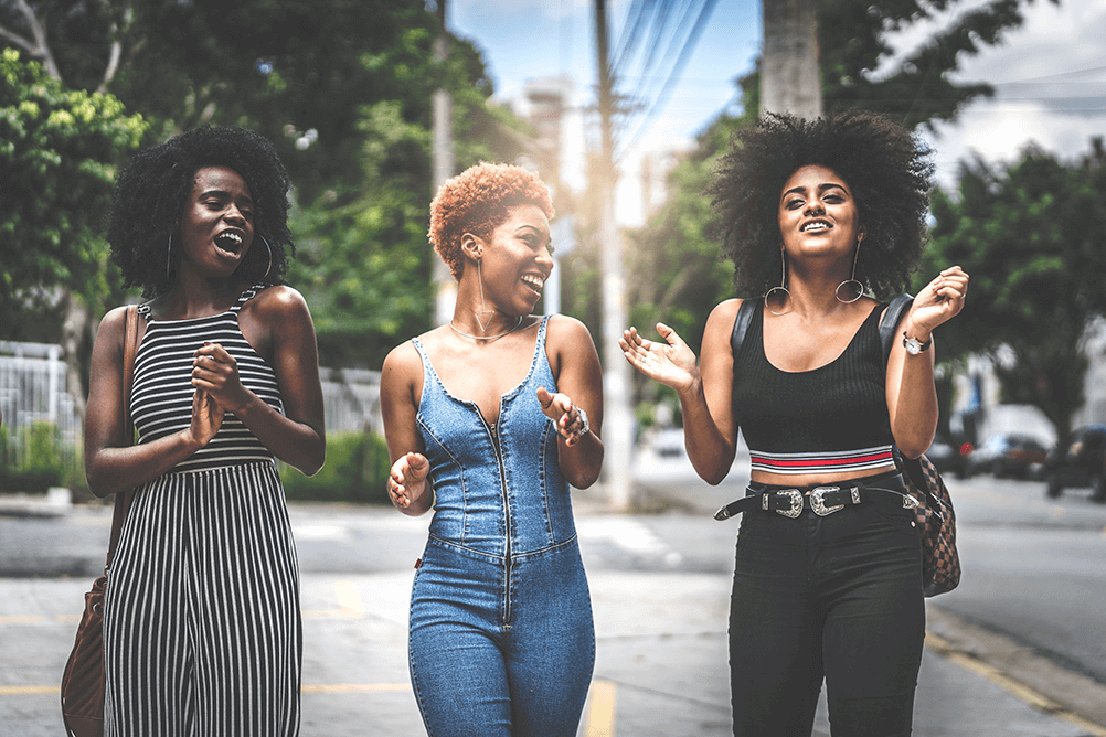 three women walking on the street discussing how to win the lotto