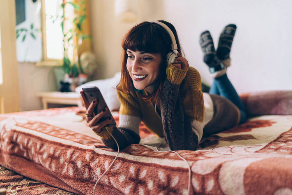 Music to overcome boredom at home Woman with headphones listening to music