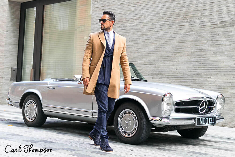 How to look rich on a budget Carl Thompson dresses like a rich man standing in front of a convertible car