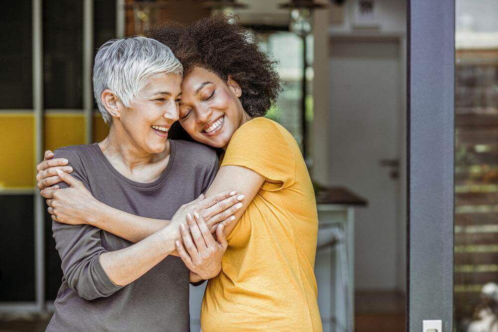International Women's Day Quotes Women hugging as they celebrate International Women's Day on March 8th