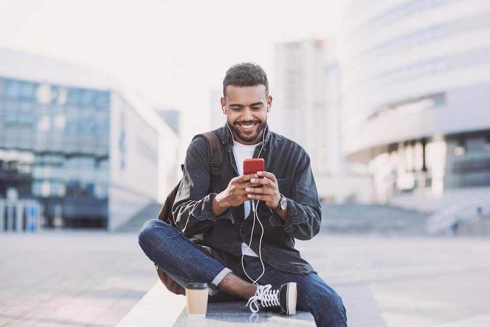 Smiling man on phone Smiling-south-african-man-playing-lottery