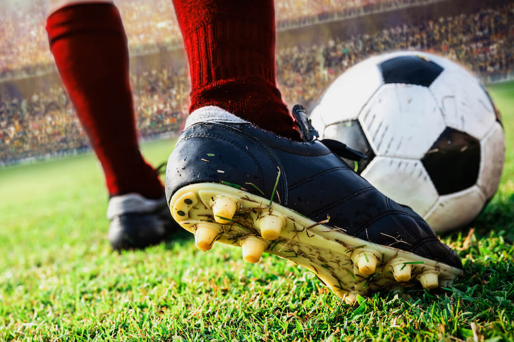 How To Bet on Sports in South Africa A close up of a ball about to be kicked by a football, learn how to bet on football with Lottoland.