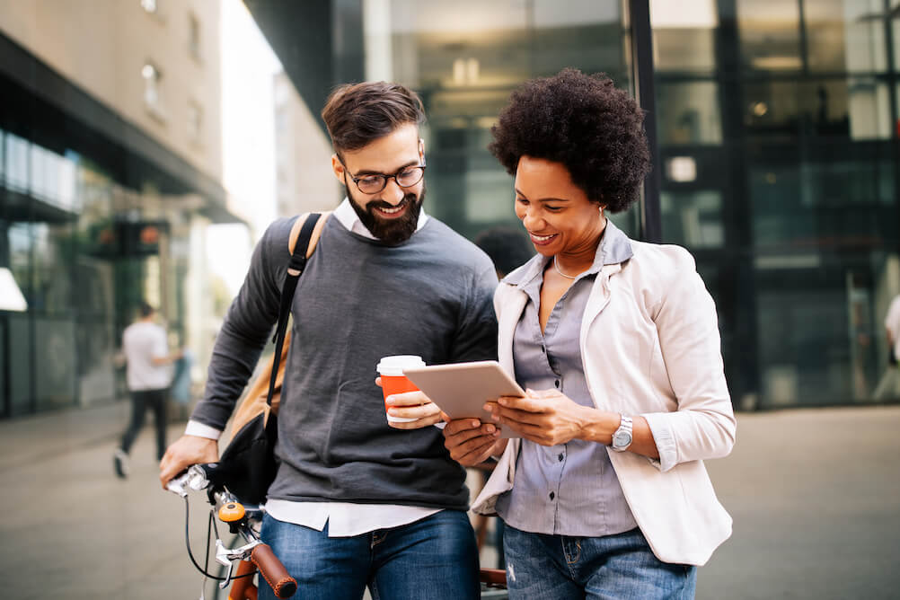 A couple walking down a street, reading about EuroDreams lottery on their tablet