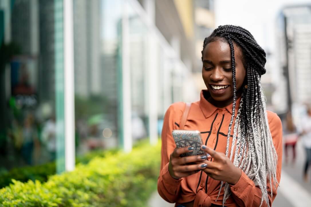 A woman on her phone reading about Lotto vs PowerBall