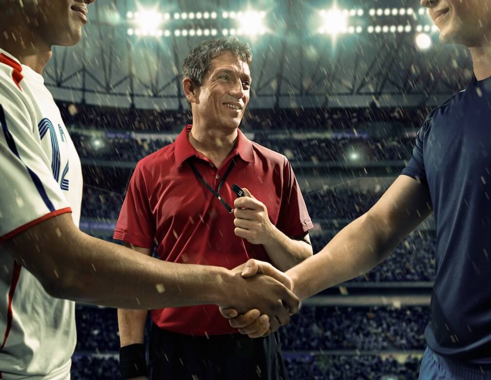 What is Evens Betting? A referee overseeing a prematch handshake before an evenly contested match with evens odds.